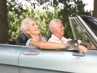 elderly couple enjoying convertible car