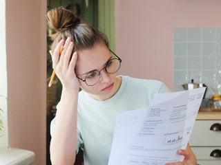 a woman with her hand on her head looking at a loan statement