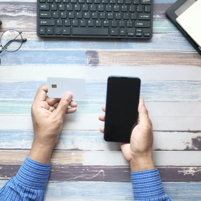 a person holding a bank card and a phone