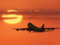 plane flying into the sunset