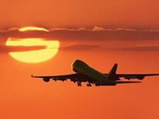 plane flying into the sunset