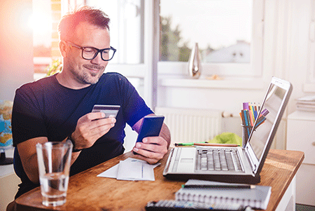 man holding bank card looking at phone