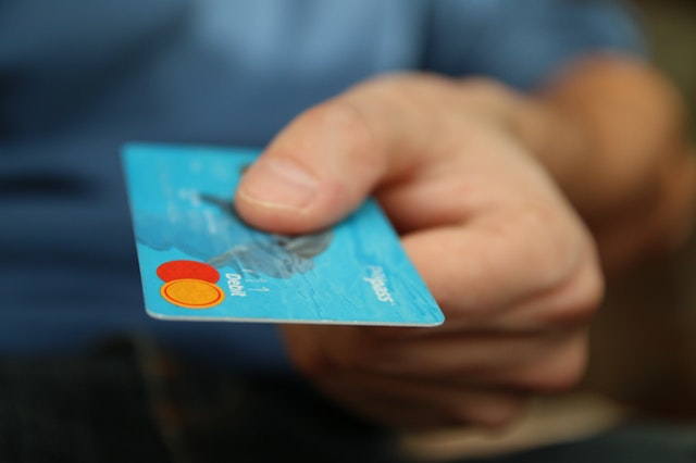 man holding blue bank card