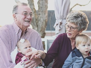 elderly couple holding children