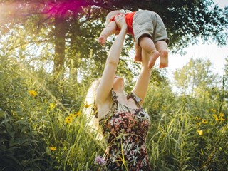 woman lifting baby in the air