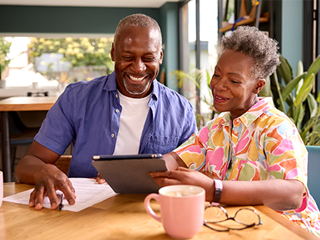 A couple comparing products using a tablet.