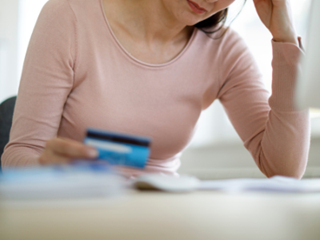 a confused woman holding her credit card
