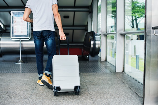 man carrying a suitcase at an airport