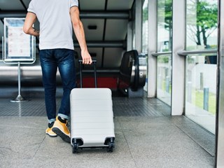 man carrying a suitcase at an airport