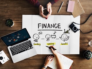finance drawing on a table top with laptop open