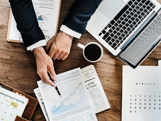 man pointing at chart on document