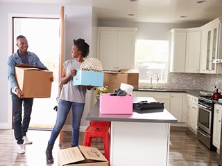 man and woman holding boxes in kitchen