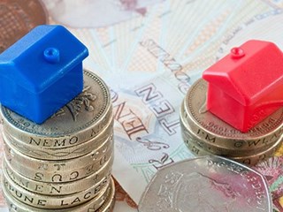 red house and blue house on top of stack of coins