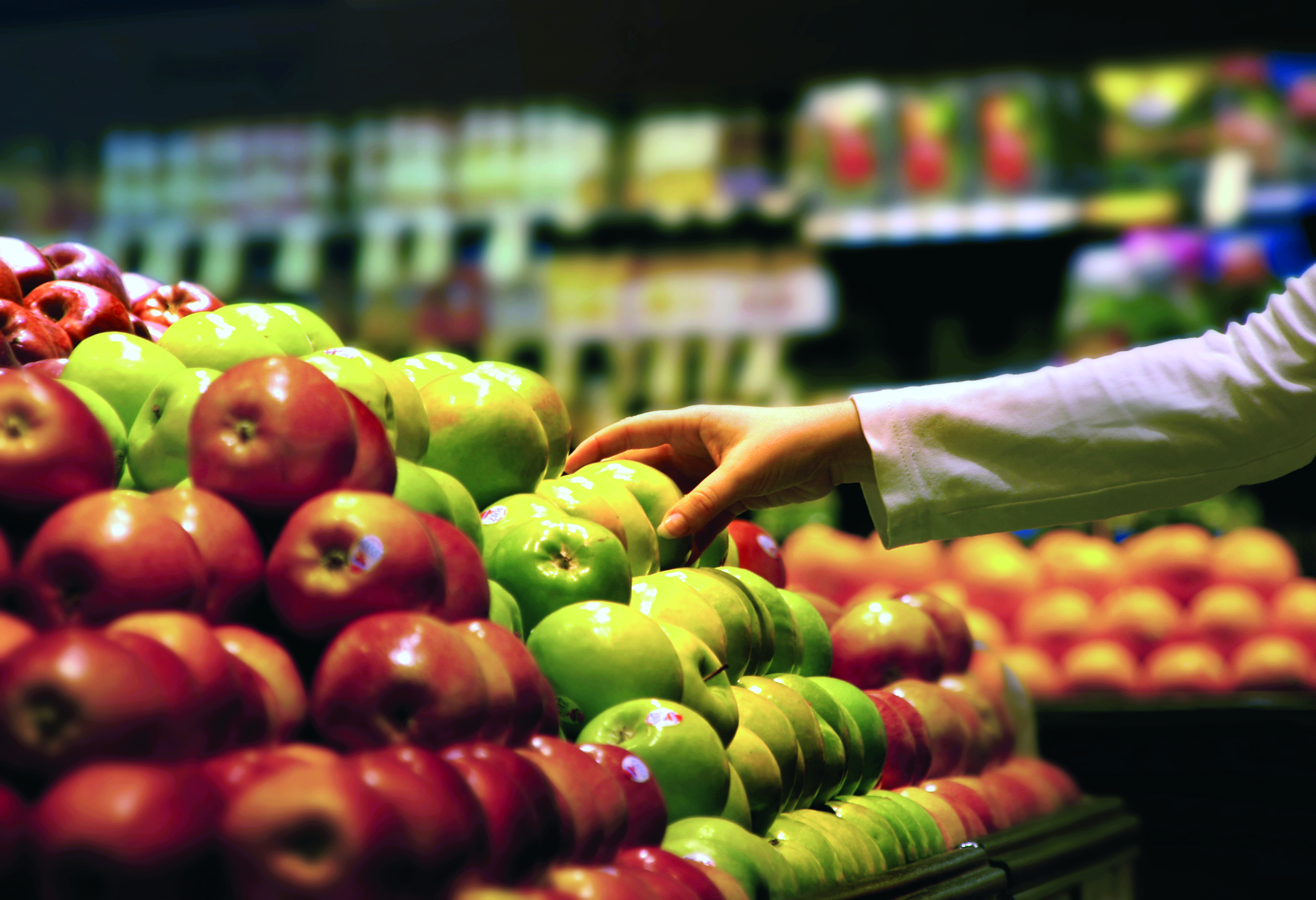 person picking fruit from a stall