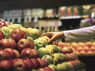 person picking fruit from a stall