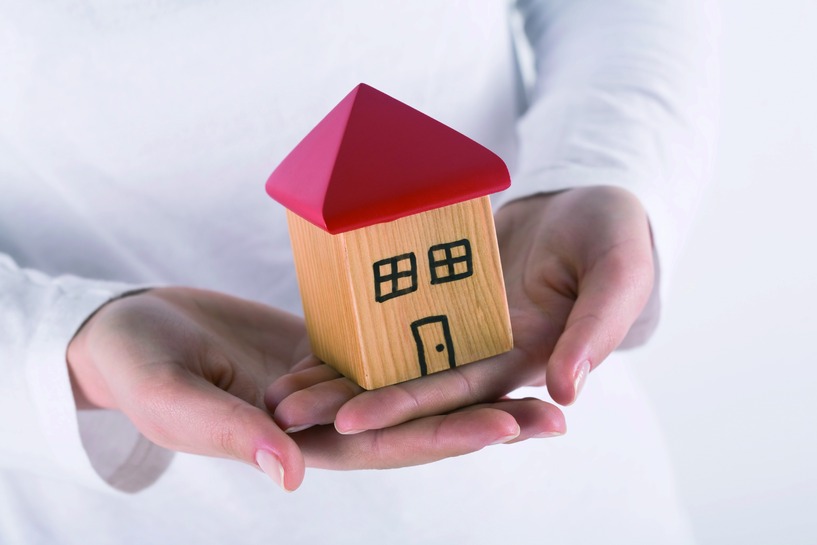 wooden model house in hands
