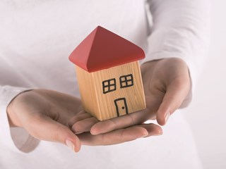 wooden model house in hands