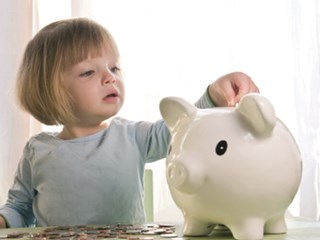 child placing money in piggybank