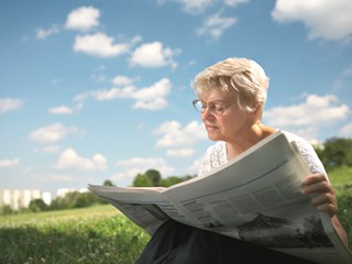 old woman reading a newspaper