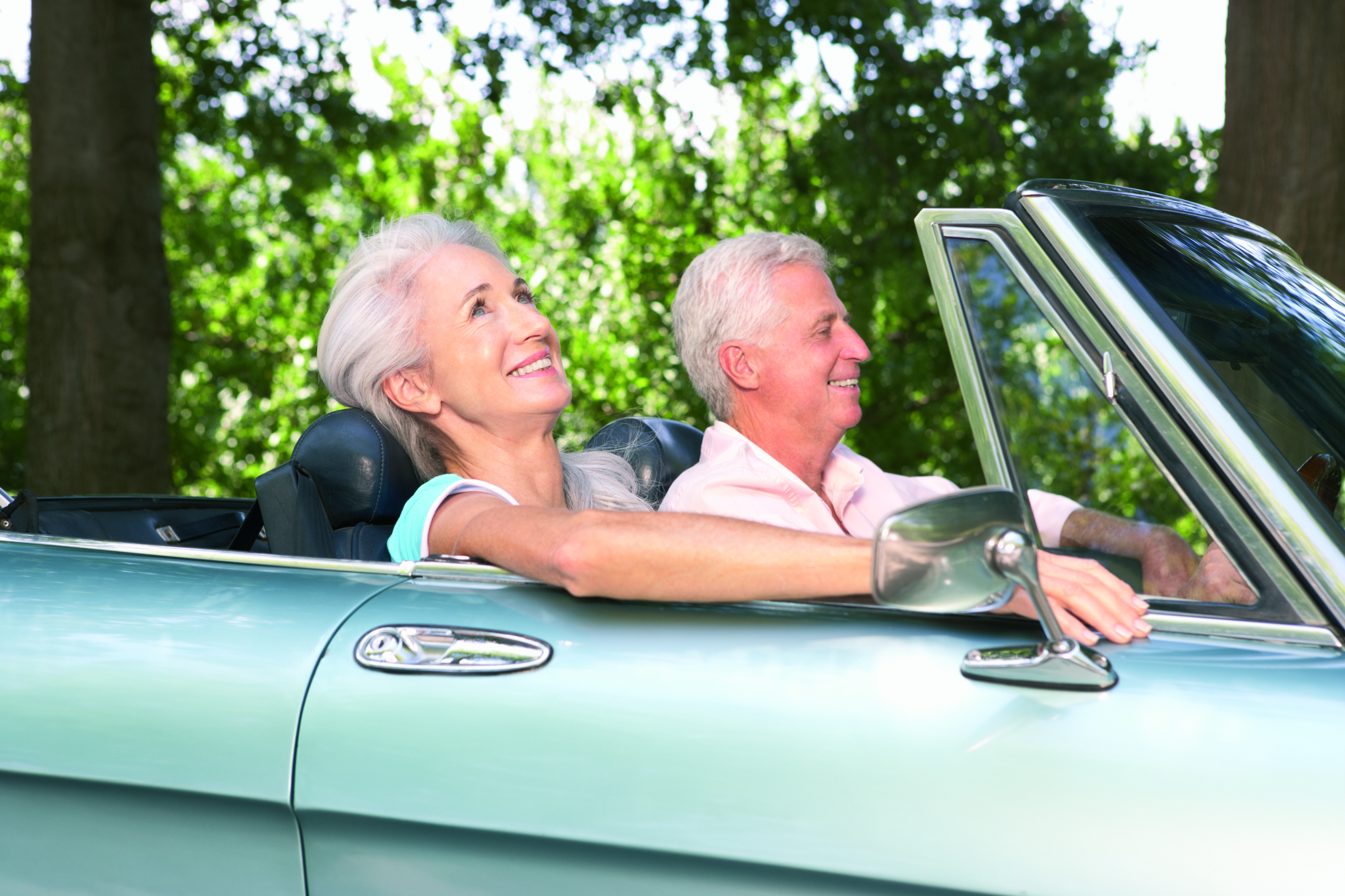 elderly couple enjoying convertible car