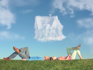 Couple lying under cloud the shape of a house