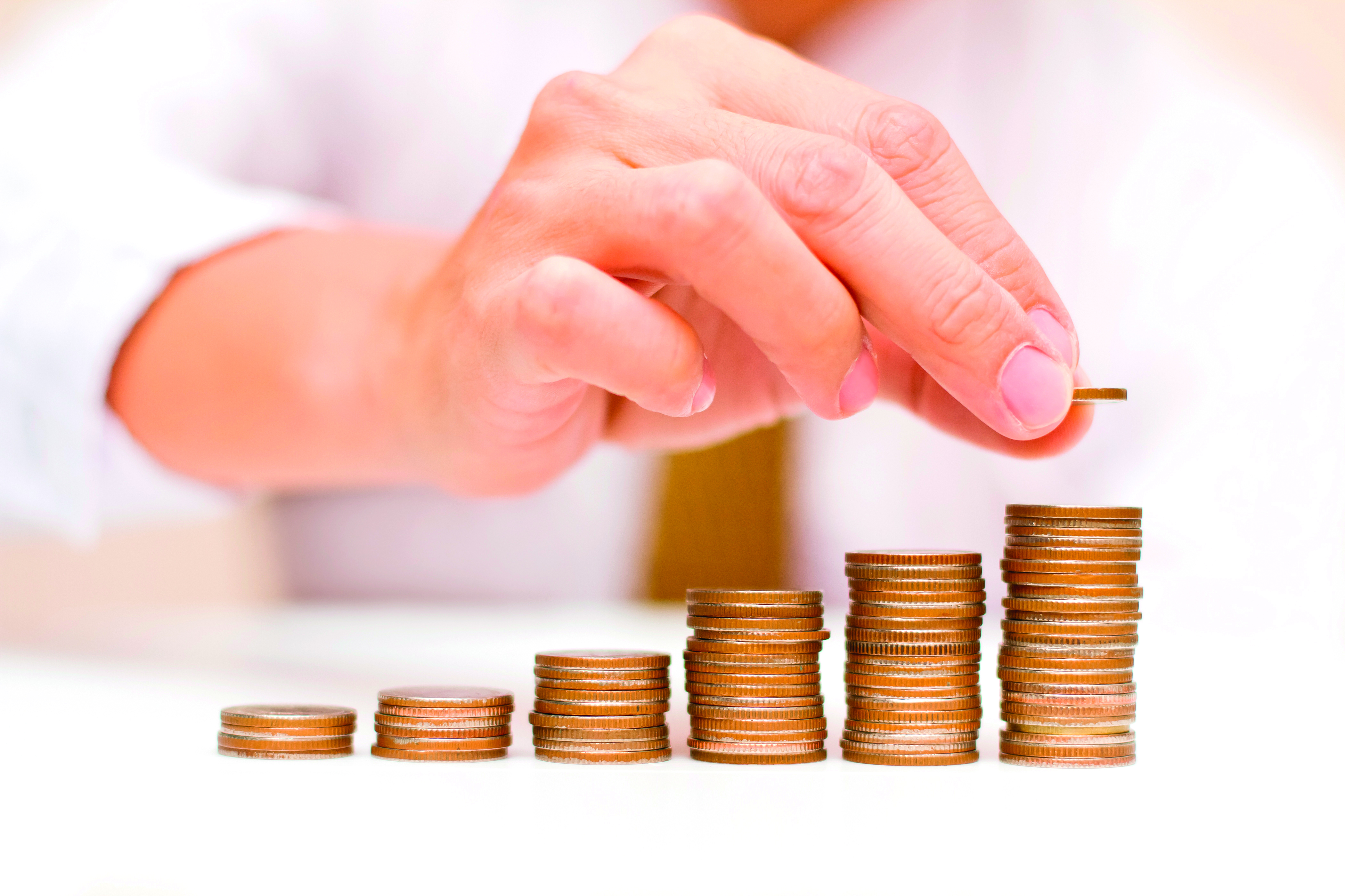 Man placing coin on a coin stack