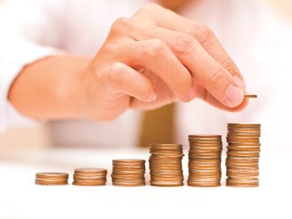 Man placing coin on a coin stack