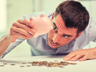 man emptying piggybank