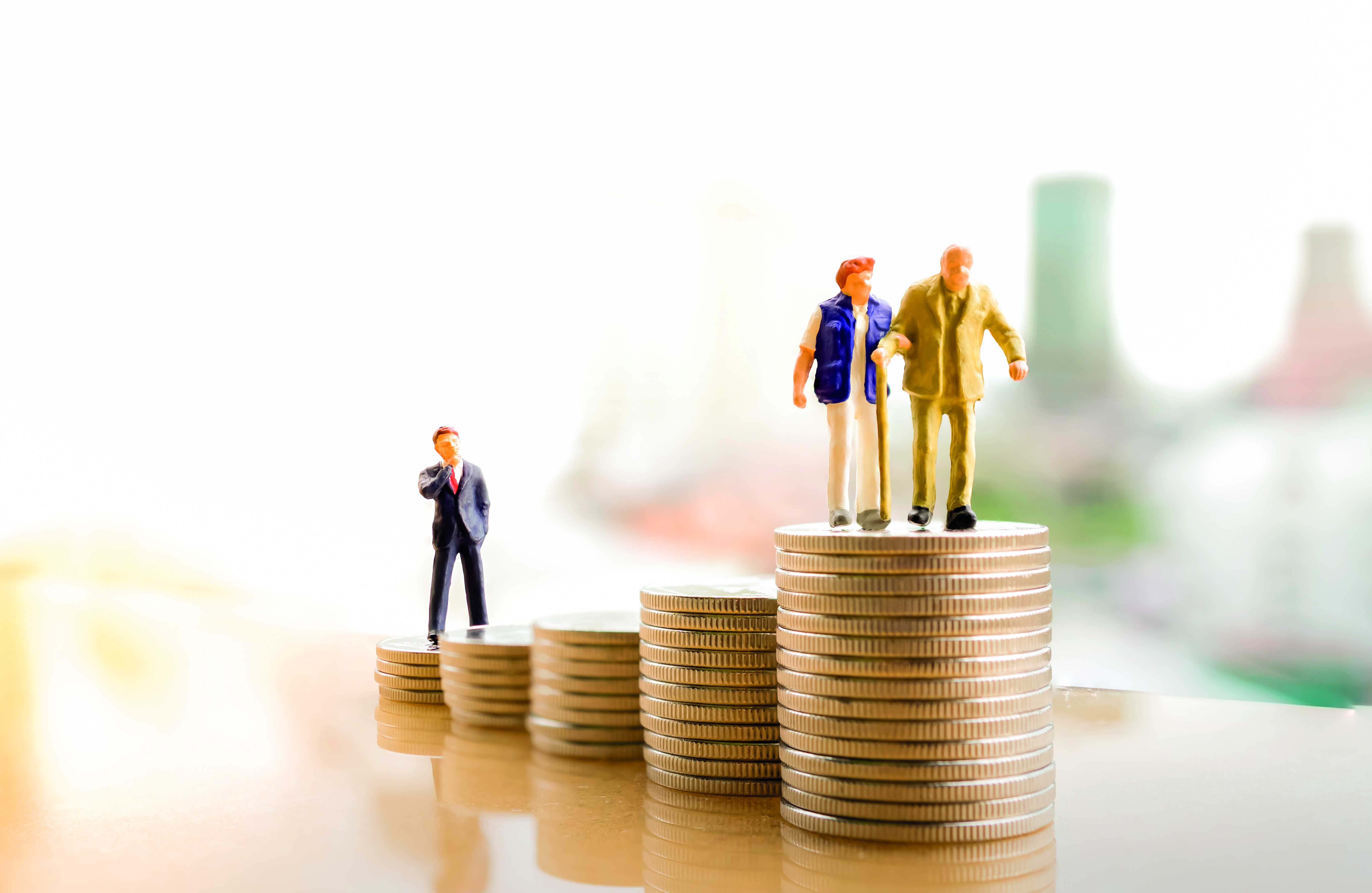 figurine of old people standing on coin stacks