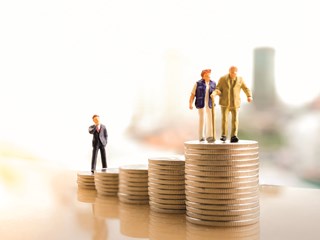 figurine of old people standing on coin stacks