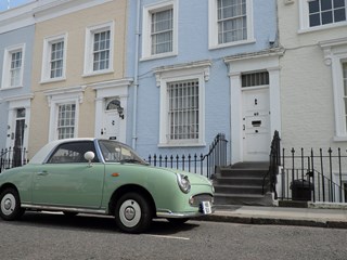 car outside colourful homes