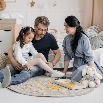Family of three sitting together on a mat