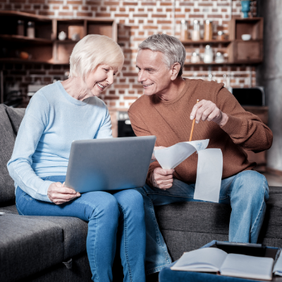 Man and woman discussing over paperwork and a laptop