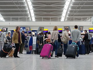 people waiting in a large queue at the airport