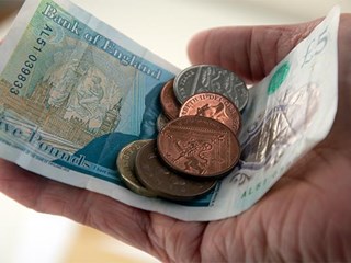 A hand holding loose change