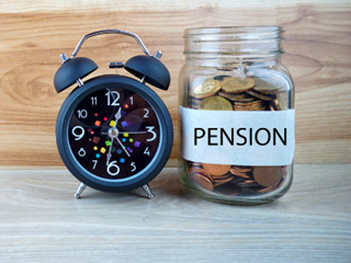 Pension jar with classic alarm clock beside it