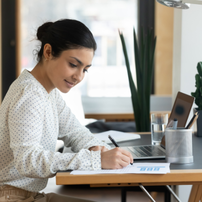 lady writing on paper at a desk