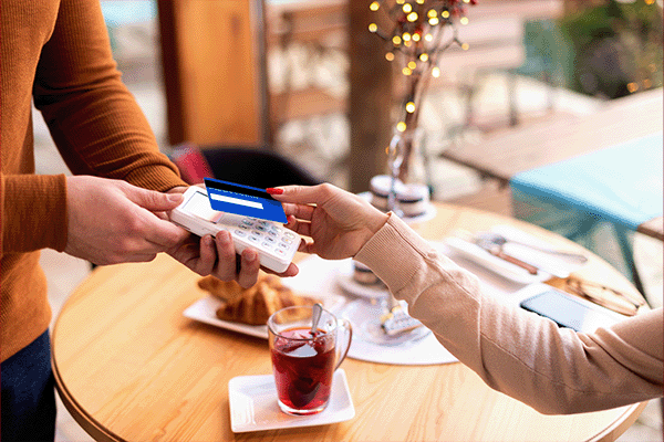 Woman in a cafe making a contactless card payment