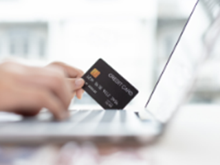 a person filling out their credit card details on the laptop