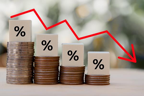 Percentage signs sitting on stacks of coins, progressively getting shorter with downward arrow.