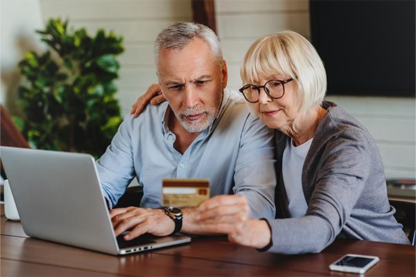 Couple with a laptop and bank card
