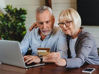 Couple with a laptop and bank card
