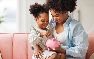 Mother and daughter holding a piggy bank