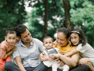 family of five sat outside on grass