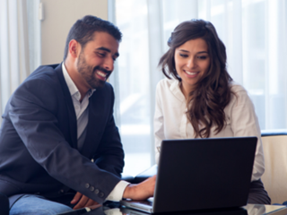 Two people looking at a laptop screen