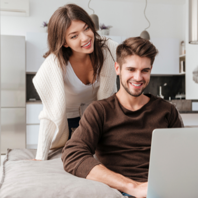 a couple smiling at a laptop screen