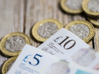 A pile of pound coins and bank notes
