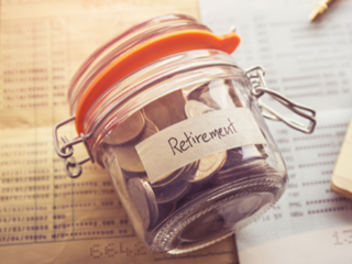 Jar of coins labelled retirement on paperwork