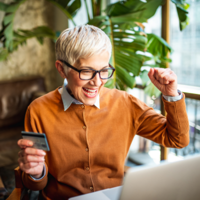 a women with a happy expression on her face looking at her laptop
