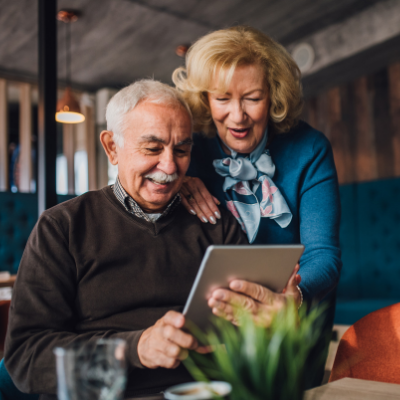 elderly couple looking at an electronic tablet